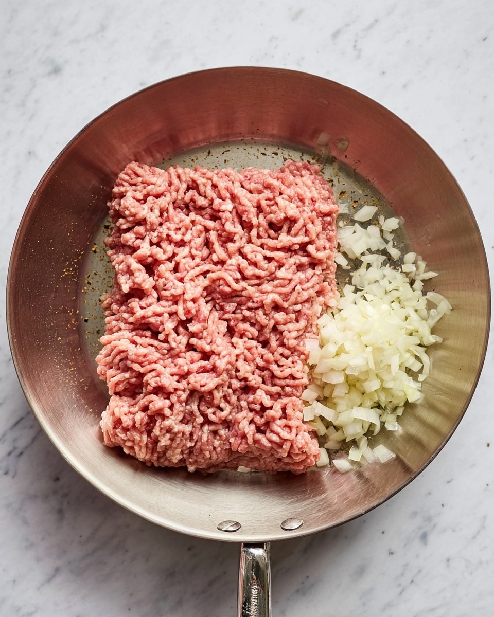 A large silver pan contains a thick rectangular layer of raw minced meat in the middle with a rough texture, mostly pinkish-red in color. On the right side of the meat, there is a small pile of finely chopped white onions and next to it is a smaller pile of small pieces of chopped garlic, both having a light, off-white color and a slightly moist look. The pan has a smooth, shiny metal surface and is placed on a white marbled texture. The photo taken with an iphone --ar 4:5 --v 7