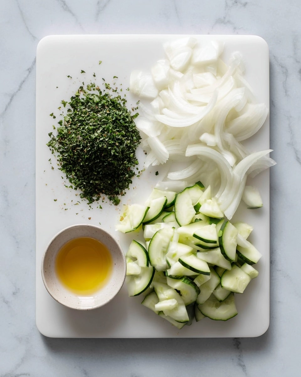 A white cutting board rests on a white marbled surface. On the left side of the board is a small pile of finely chopped green herbs, showing many small pieces with rough edges and different shades of green. On the right side of the board are chopped cucumber pieces in irregular shapes, mostly small chunks and half-moon slices. The cucumber pieces have dark green skin with a smooth texture and pale green inside. The image is bright with soft natural light, and the scene looks fresh and clean. photo taken with an iphone --ar 4:5 --v 7