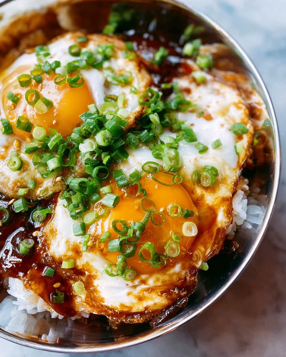 A close-up view of a metal bowl filled with a layered dish. The bottom layer is white rice, partially visible around the edges. On top of the rice, there is a dark brown sauce covering the surface. Two fried eggs with bright golden yolks and whites slightly crispy on the edges are placed on the sauce layer. The eggs are sprinkled with fresh, bright green chopped scallions. The whole bowl rests on a white marbled surface. photo taken with an iphone --ar 4:5 --v 7