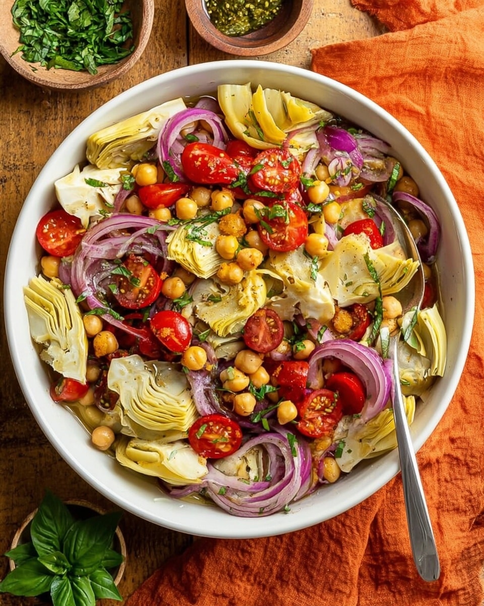 A white bowl filled with a colorful salad shows several layers, starting with pale yellow artichoke pieces cut in halves and quarters spread mostly on the top and center. Bright red, halved cherry tomatoes are scattered among thin, curved rings of purple-red onion. Light tan chickpeas are spread evenly throughout the bowl, mixed with fresh green chopped herbs. The texture of the salad looks fresh and slightly juicy, with a spoon resting inside on the right side. The bowl is placed on a wooden surface covered partly by an orange cloth, with small bowls of chopped green herbs and fresh basil nearby. Photo taken with an iphone --ar 4:5 --v 7
