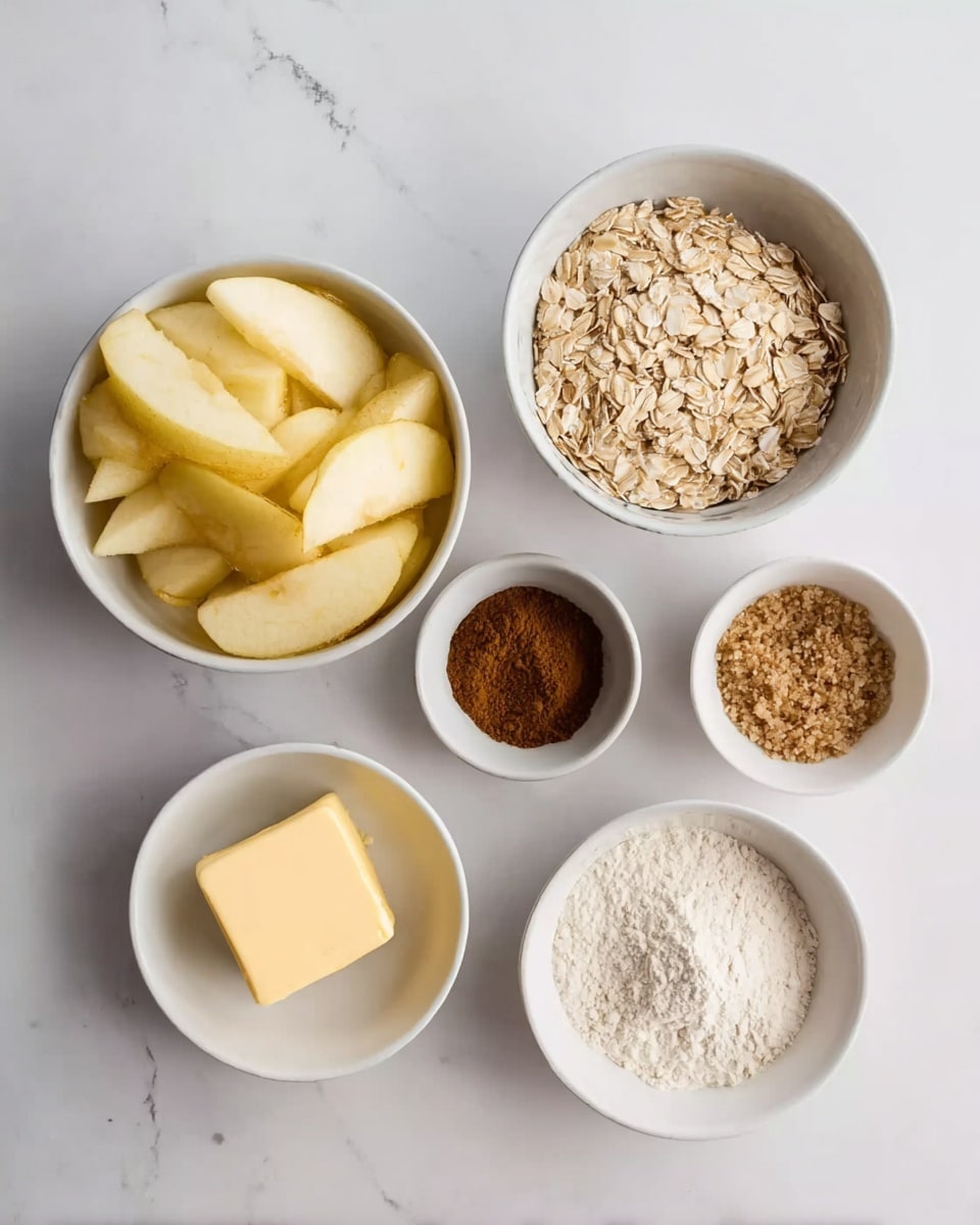 The image shows six white bowls placed on a white marbled surface, each holding different ingredients. Starting from the bottom left, a bowl is filled with light yellow sliced apples. Above it, a small bowl contains a dark brown powder, likely cinnamon. To the right of the cinnamon, a bowl is filled with light beige oats. Next to the oats, on the far right, is a bowl with a light brown granulated ingredient, probably brown sugar. Below the brown sugar, there is a small bowl with white flour-like powder. In the center bottom, a bowl contains a square piece of pale yellow butter. Photo taken with an iphone --ar 4:5 --v 7