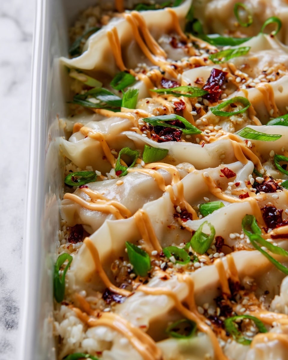 The image shows a close-up view of dumplings arranged closely together on a bed of light-colored rice in a white rectangular dish. The dumplings have pale, slightly translucent wrappers with delicate folds and some light browning on the edges. They are topped with thin lines of creamy orange sauce drizzled diagonally, along with small green onion slices and white sesame seeds scattered evenly. There are also small spots of dark red chili oil and bits of finely chopped garlic or ginger around the dumplings, adding texture and color contrast. The dish sits on a white marbled surface. photo taken with an iphone --ar 4:5 --v 7