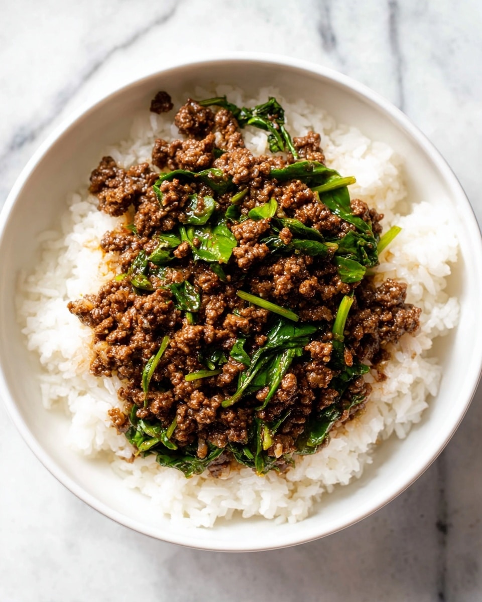 A white bowl holds two layers: the bottom layer is plain white rice with soft, separate grains, and the top layer is a dark brown cooked ground meat mixed with bright green leafy vegetables, spread evenly over the rice. The sauce on the meat adds a shiny, slightly wet look. The bowl is set on a white marbled surface. Photo taken with an iphone --ar 4:5 --v 7