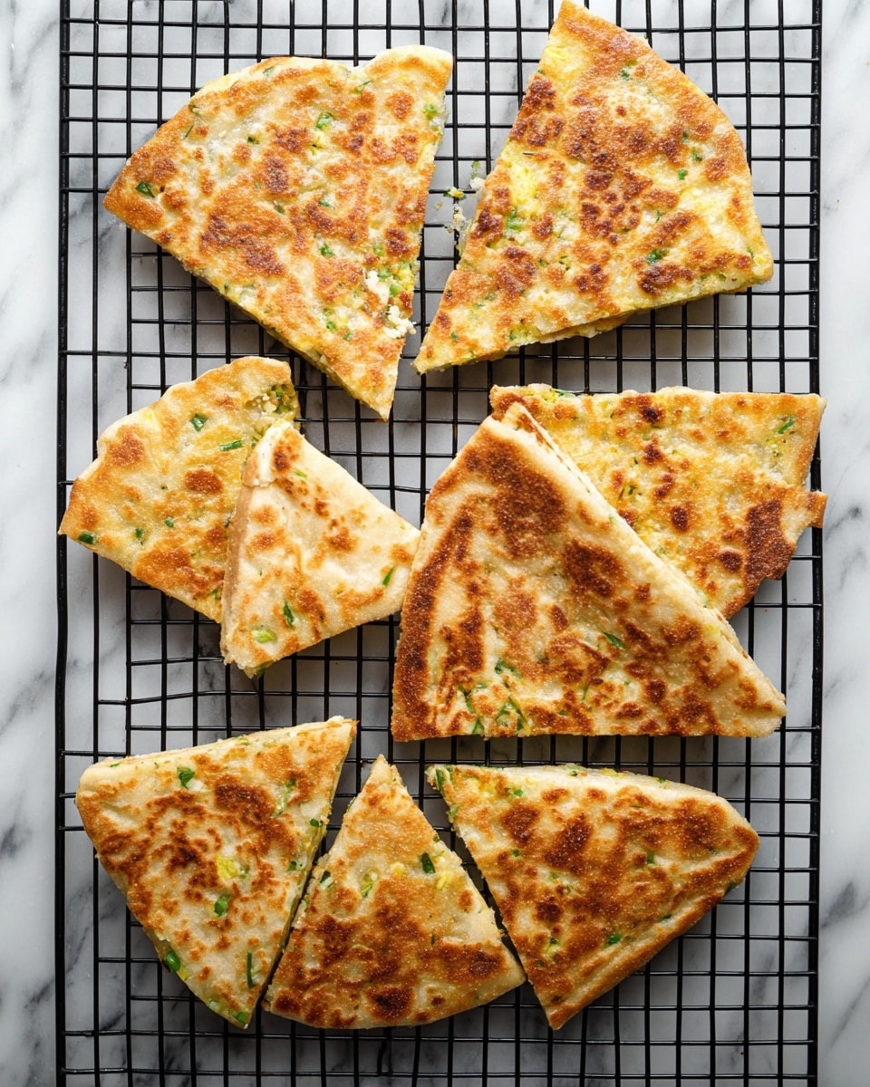 The image shows eight pieces of flatbread cut into triangle shapes, laid out on a black cooling rack. Each piece has a golden-brown crispy texture with spots of lighter and darker browns, showing a slightly uneven surface. Small green herb bits are visible scattered inside the flatbread, adding a touch of color. The cooling rack rests on a white marbled surface, which contrasts with the warm tones of the flatbread. The overall look is rustic and fresh, with a focus on the toasted texture and the herb details. photo taken with an iphone --ar 4:5 --v 7