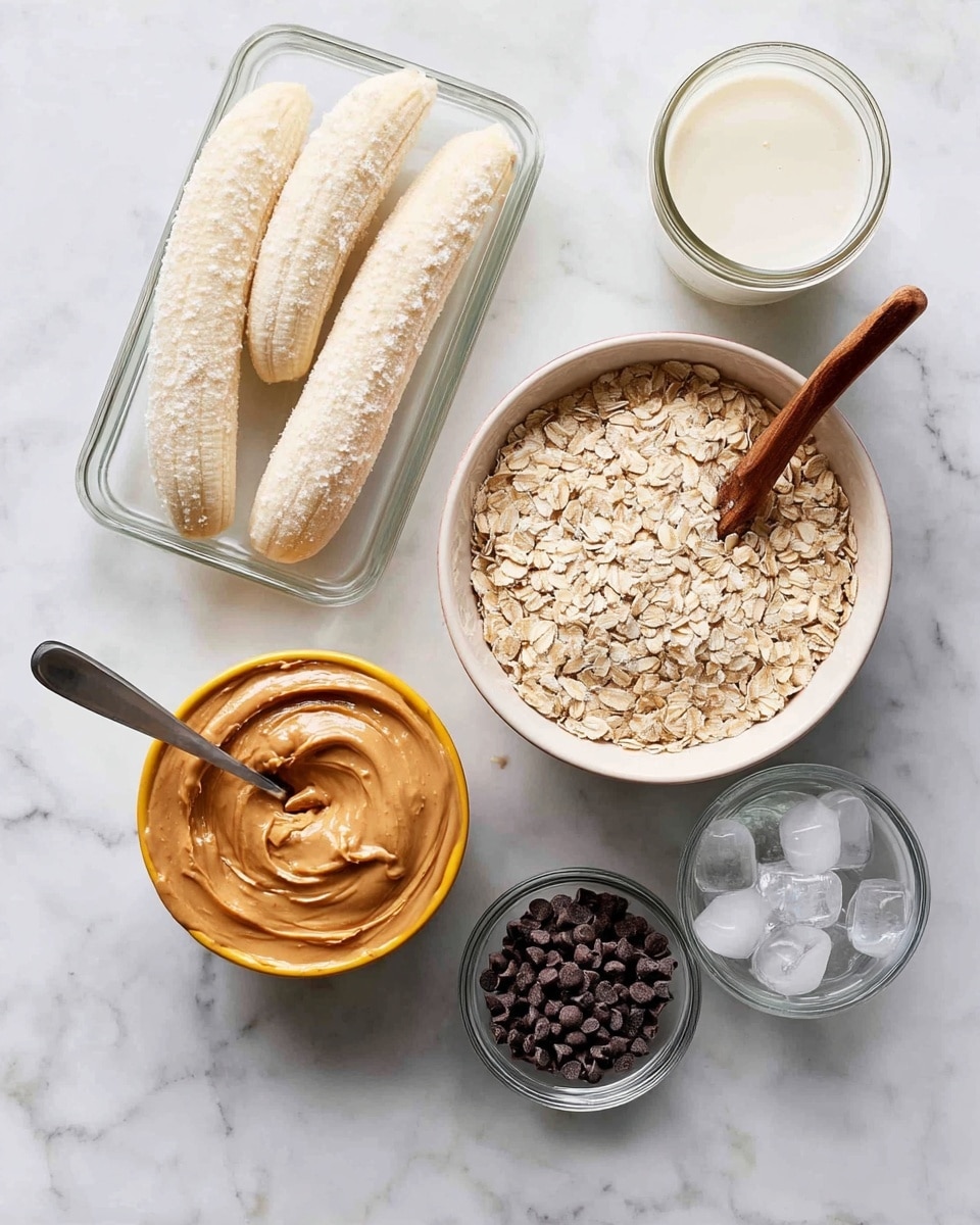 The image shows six main elements arranged on a white marbled surface. At the top left, there is a clear rectangular glass dish holding four peeled bananas covered in a light layer of frost. Below this dish, a large white bowl is filled with pale beige rolled oats, with a wooden spoon resting on top, partially inside the oats. To the right of the oats is a round yellow container filled with creamy, smooth peanut butter, with a metal spoon standing in it. Above the peanut butter, there is a small glass jar filled with white liquid, likely milk or a milk alternative, visible through the clear glass. To the lower right of the peanut butter, a small glass bowl contains numerous tiny, dark brown chocolate chips. Finally, in the bottom center, there is a small clear glass bowl filled with ice cubes. The overall setup is clean and well-organized, with all items displayed clearly. photo taken with an iphone --ar 4:5 --v 7