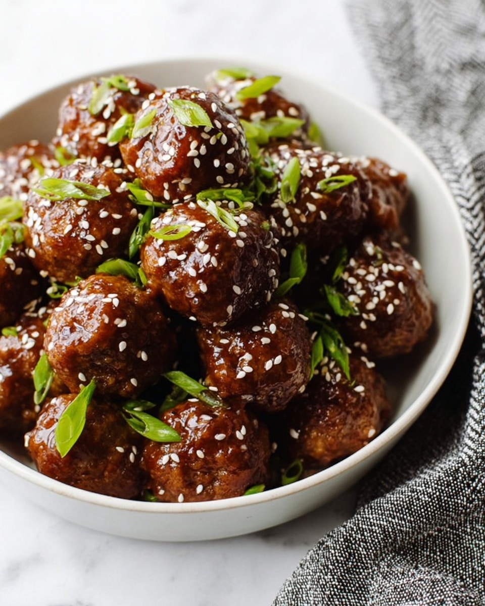 A white bowl filled with shiny brown meatballs covered in sticky sauce, sprinkled with white sesame seeds on top. Thin pieces of green onion are spread over the meatballs, adding a fresh green touch. The bowl sits on a white marbled surface with part of a black and white cloth visible nearby. The meatballs look moist and well-coated with sauce, showing texture from the seeds and chopped onions. photo taken with an iphone --ar 4:5 --v 7