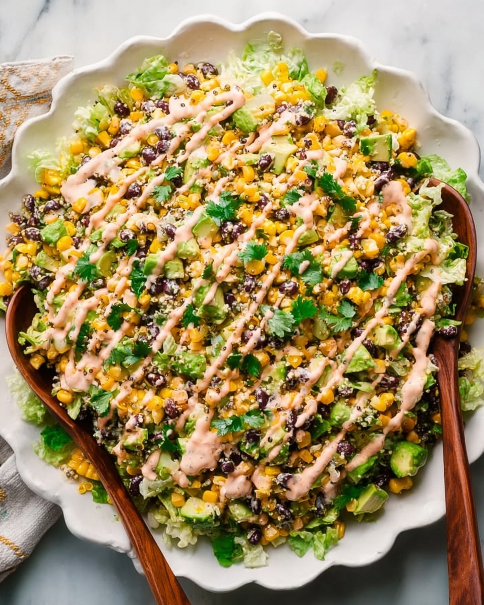 A large white scalloped plate filled with a colorful layered salad. The bottom layer is light green chopped lettuce mixed with black beans and yellow corn scattered evenly throughout. On top, there are small cubes of green avocado and bits of chopped cilantro adding fresh green touches. Drizzled over the salad is a creamy light pink dressing in thin lines, spread across the whole dish. Two wooden salad spoons rest on the edge of the plate, partially in the salad. The plate sits on a white marbled surface. Photo taken with an iphone --ar 4:5 --v 7