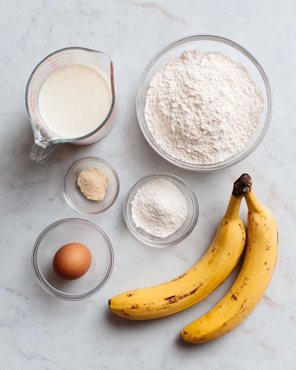 The image shows six ingredients arranged on a white marbled surface: a clear glass measuring cup with white milk on the top left, a medium clear glass bowl filled with white flour in the top center, a small clear glass bowl on the top right holding three powders light brown, white, and off-white beside two yellow bananas with brown spots on the far right. Below these, there is a small clear glass bowl with a single brown egg in the bottom left center. All items are spaced with a clean and minimal style, viewed from above. photo taken with an iphone --ar 4:5 --v 7