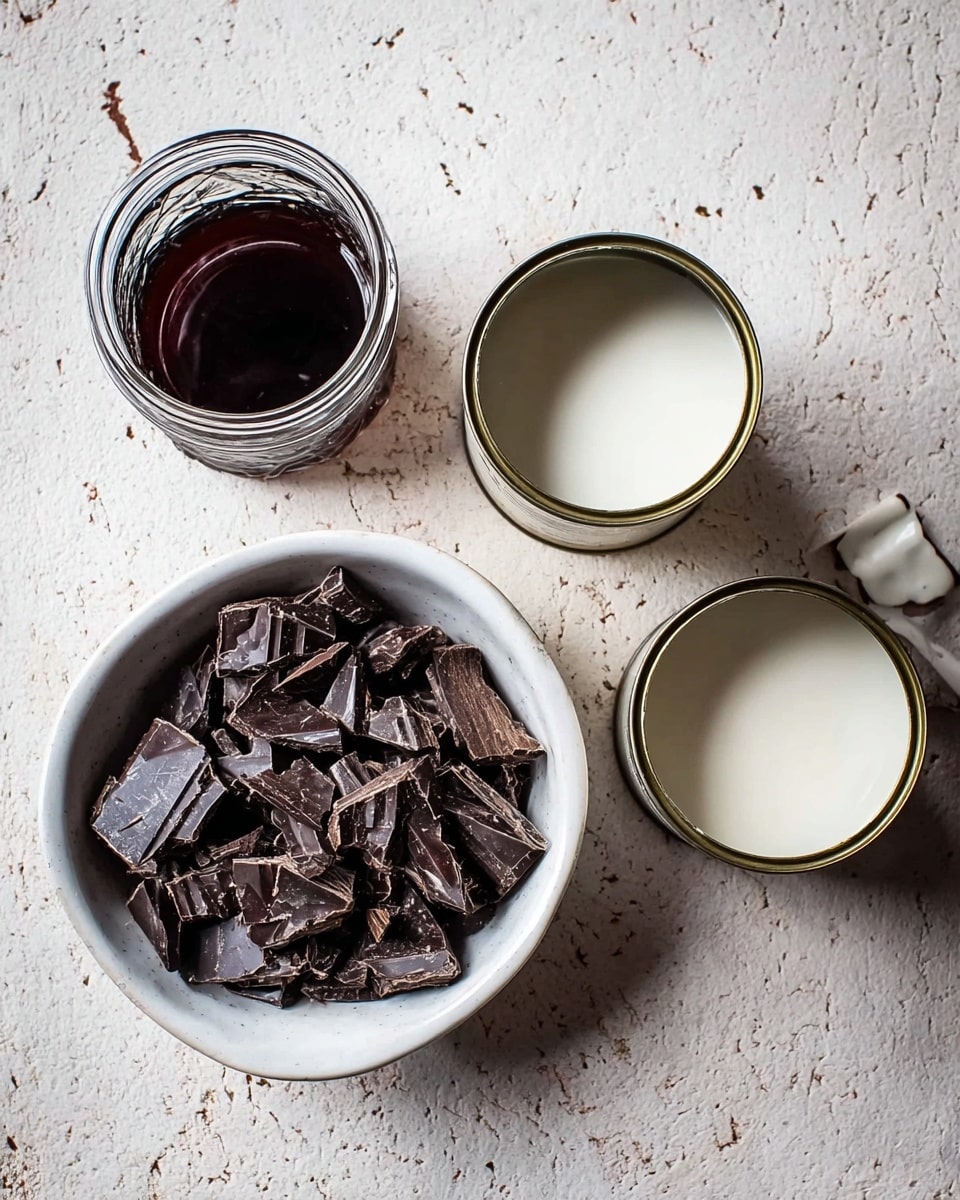 The image shows a white bowl filled with broken dark chocolate pieces, placed on a white marbled surface. To the left of the bowl, there is a small glass jar filled with thick dark liquid. To the right of the bowl, there are two open cans filled with white creamy liquid, with the lids peeled back and leaning on the cans. The overall look is simple and natural with a focus on the rich textures of the chocolate and liquids photo taken with an iphone --ar 4:5 --v 7