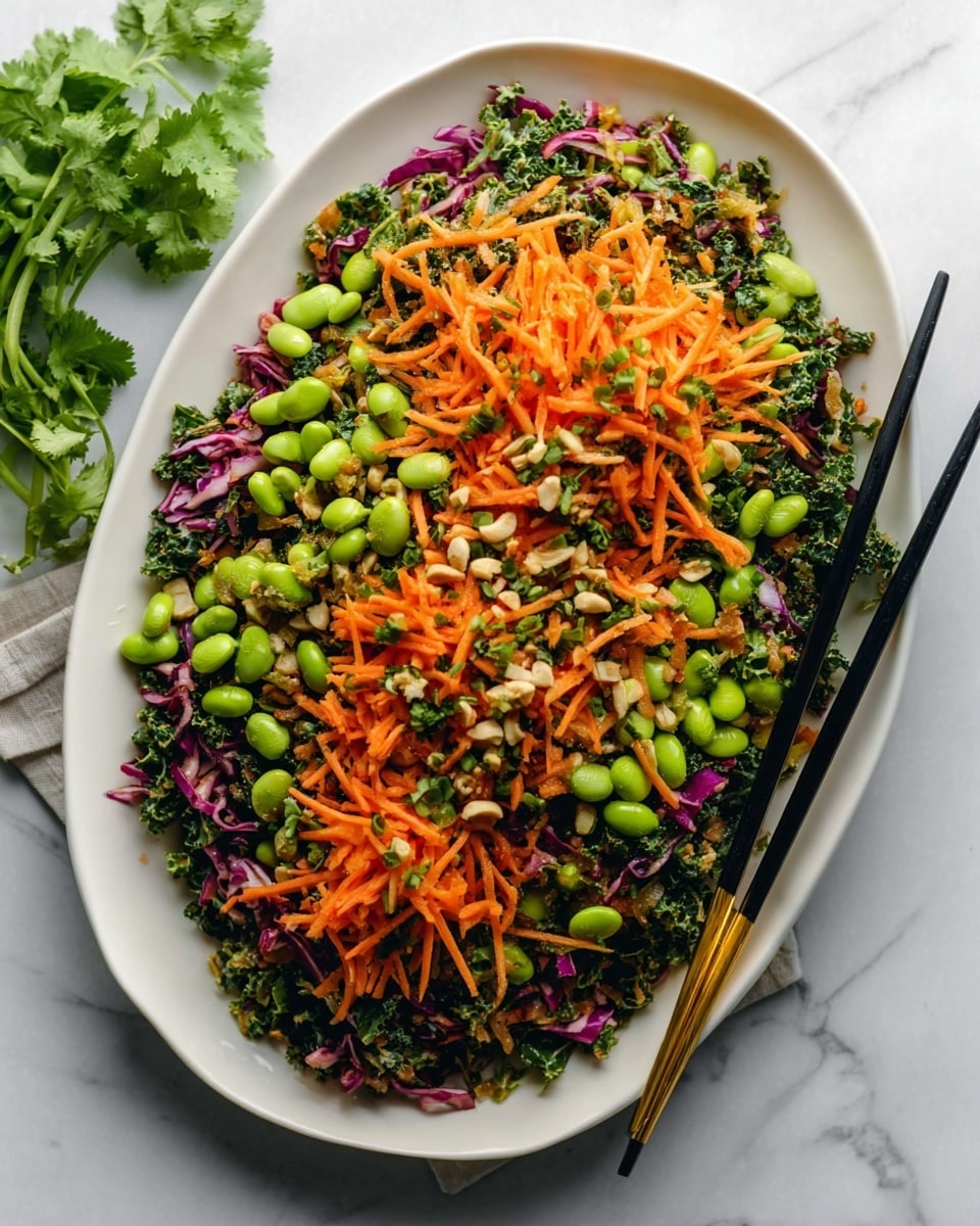 A white oval plate is filled with a colorful mixed salad featuring bright green edamame beans, thin orange carrot strips, dark green kale, and small pieces of purple cabbage, all evenly mixed together creating a textured and vibrant heap. The salad has a fresh, slightly glossy look, indicating a light coating of dressing. On the right side of the plate, two black chopsticks with gold tips rest partially inside the salad. The plate sits on a white marbled surface, with a small green cilantro sprig partially visible in the top left corner. Photo taken with an iphone --ar 4:5 --v 7