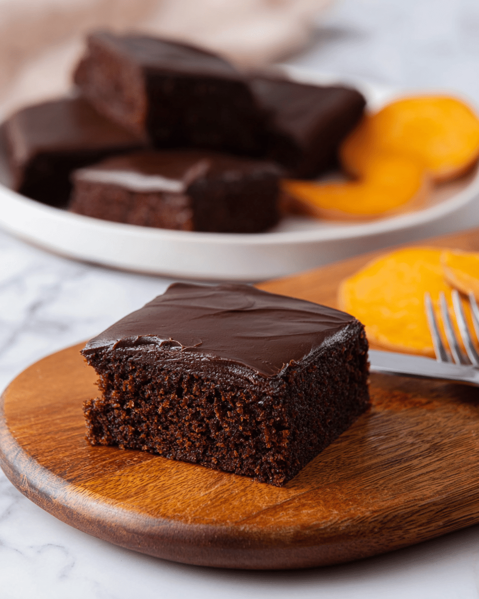 A single square piece of chocolate cake with two layers is placed on a round wooden board. The bottom layer is dark brown and moist with a soft texture, while the top layer is a smooth, shiny dark chocolate frosting that covers the entire surface evenly. In the background, there is a white plate holding several similar square pieces of chocolate cake. Next to the cakes, there are a few slices of sweet potato with bright orange and smooth surface, and a silver fork lies along the side of the board. The whole scene is set on a white marbled surface. photo taken with an iphone --ar 4:5 --v 7