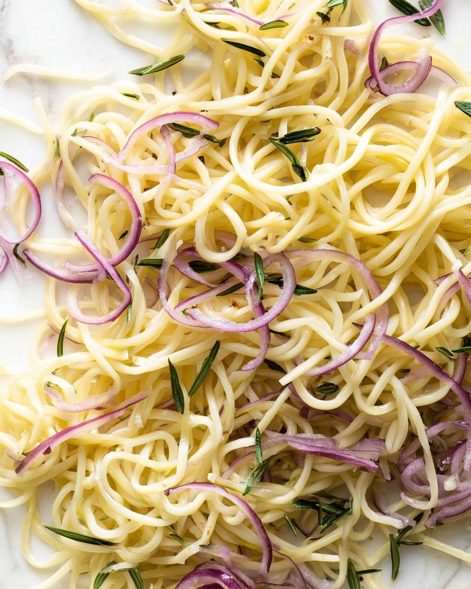 This image shows a close-up of one layer of light yellow spiral noodles mixed with thin purple onion slices and small dark green rosemary sprigs scattered evenly throughout the noodles. The noodles have a smooth, glossy texture and look soft and lightly cooked. The background is a white marbled surface that contrasts with the noodles and herbs, making the colors stand out clearly. Photo taken with an iphone --ar 4:5 --v 7