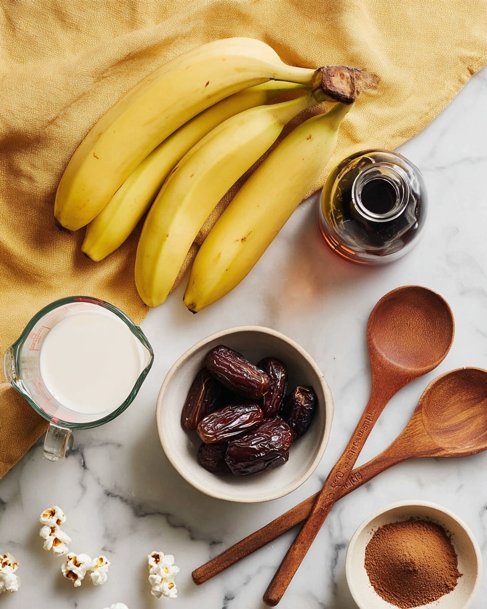 The image shows a white marbled surface with three yellow bananas arranged diagonally at the top left. To the right of the bananas, there is a small glass bottle filled with dark liquid. Below the bananas, three wooden measuring spoons lay overlapping, and next to them is a small white bowl filled with dark brown dates. To the bottom left, a clear measuring jug is filled with white liquid, and at the bottom right, part of a white dish with brown powder is visible. The background includes a soft yellow cloth with some scattered white popcorn pieces. Photo taken with an iphone --ar 4:5 --v 7