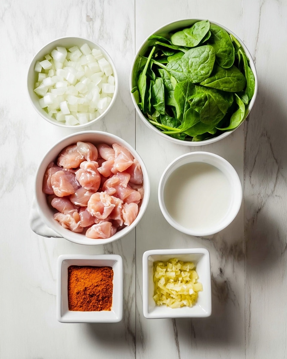 The image shows six white bowls of different sizes placed on a white marbled surface. In the top left, there is a bowl filled with small, white chopped pieces of onion. To its right, a bigger bowl holds bright green fresh spinach leaves. Below the onion bowl, a small empty bowl rests. In the center below the spinach, a medium bowl contains raw, pinkish pieces of chicken. On the lower right side, there are two small square bowls; the one on the left has red-orange powdered spice, and the one on the right holds finely chopped yellow ginger. The arrangement is clean and organized, with each bowl clearly visible. Photo taken with an iphone --ar 4:5 --v 7