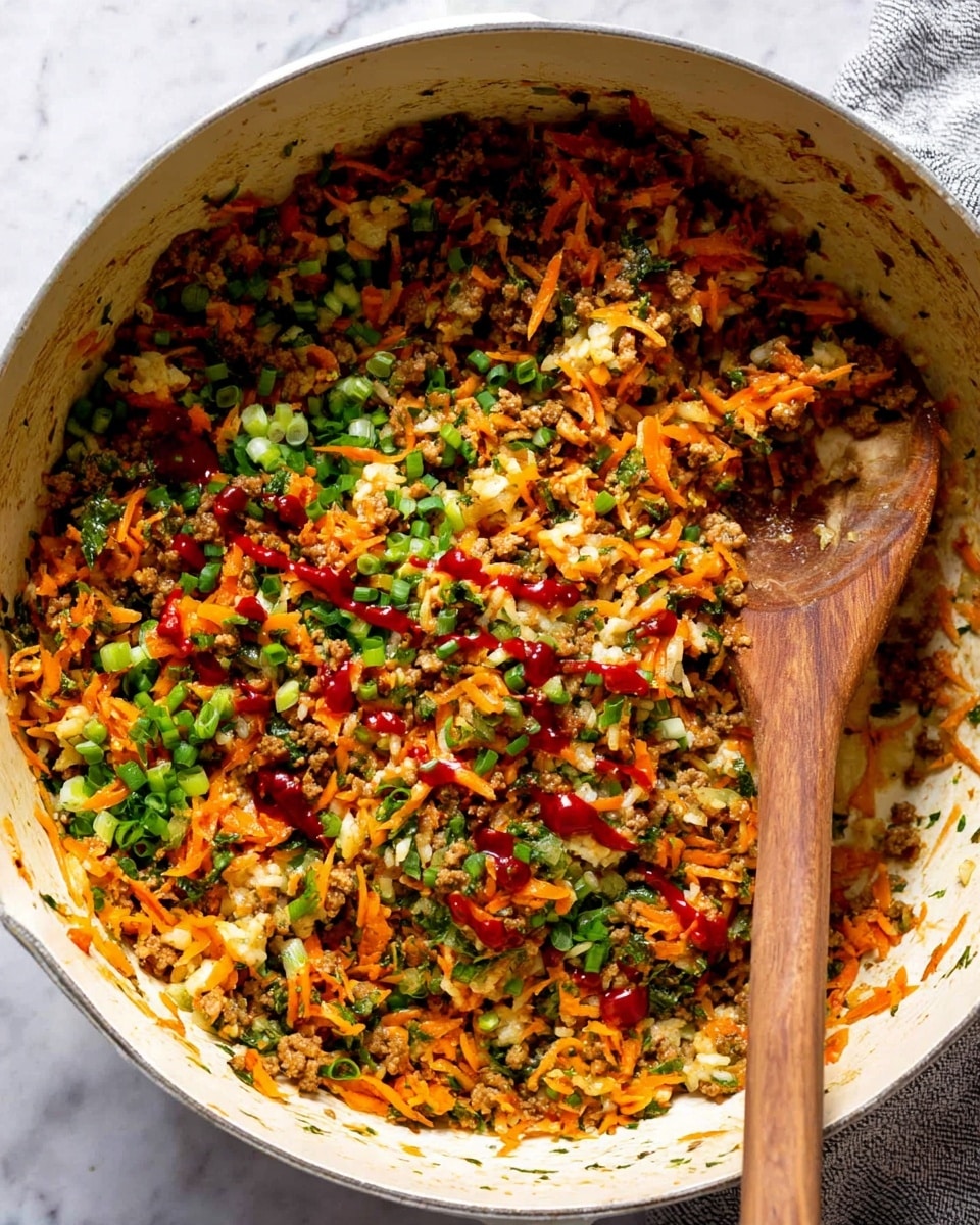 The image shows a large white pot filled with a colorful mix of cooked ground meat and shredded carrots, mixed with small pieces of green herbs and chopped green onions scattered on top. Some red sauce is drizzled over the dish, adding a bright splash of color. A wooden spoon rests inside the dish on the right side, partly covered by the food. The pot is set over a white marbled surface. photo taken with an iphone --ar 4:5 --v 7